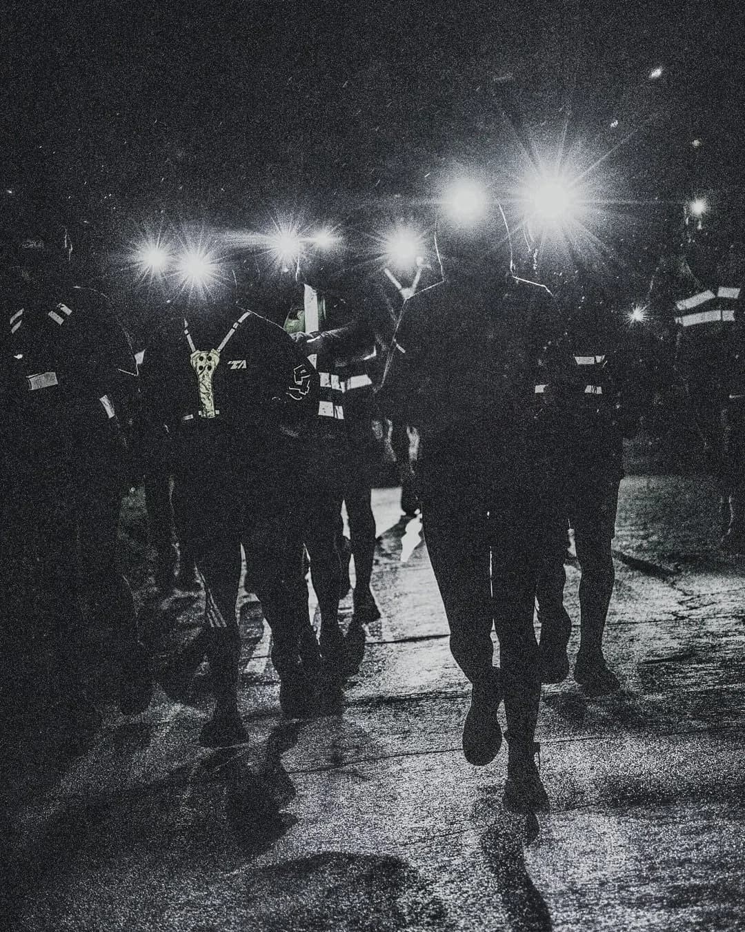 A group of Last Soul Ultra runners moving through darkness with headlamps